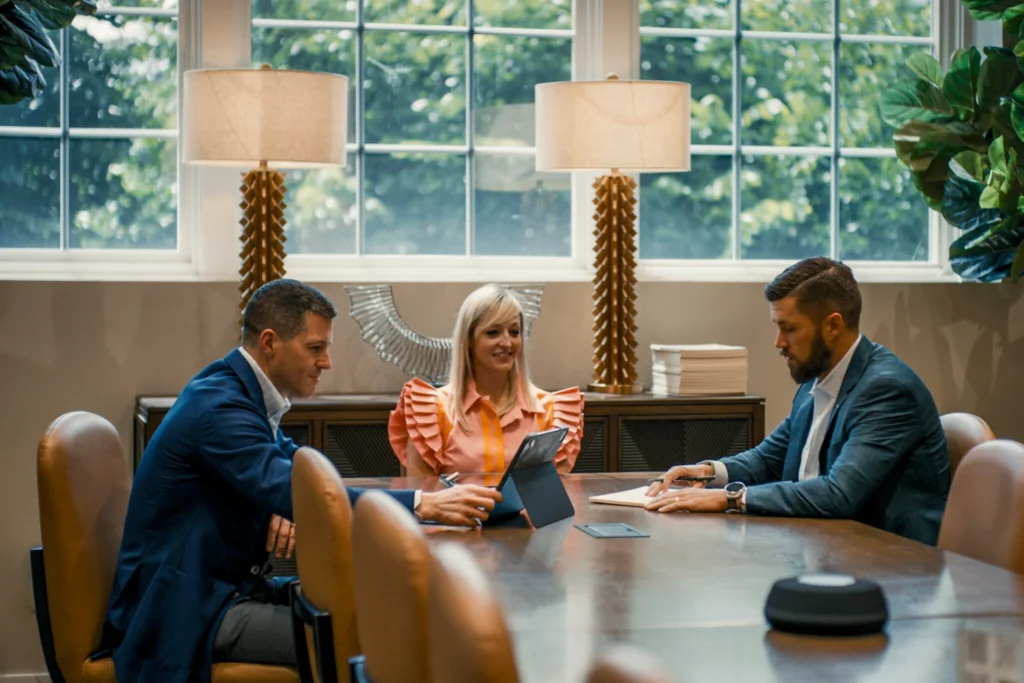 people sitting in a room around a table.